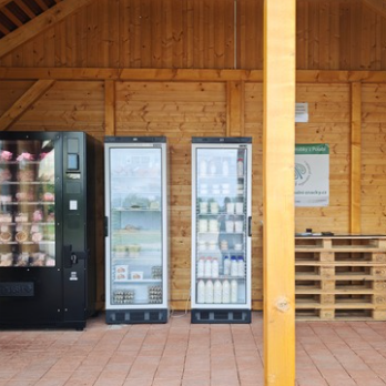 Prodejní automat a lednice v dřevěném přístřešku